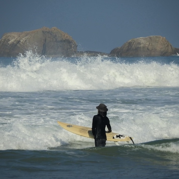Surfer entering the ocean near Hikkaduwa beach, just minutes from Kundala House eco stay.