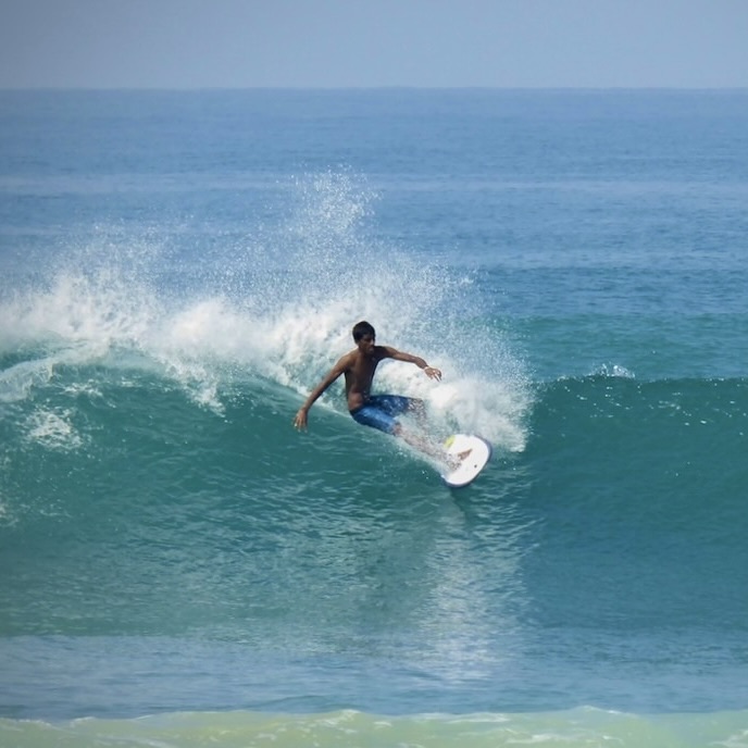 Surfing wave in Hikkaduwa, Sri Lanka, a popular surf spot close to Kundala House eco retreat